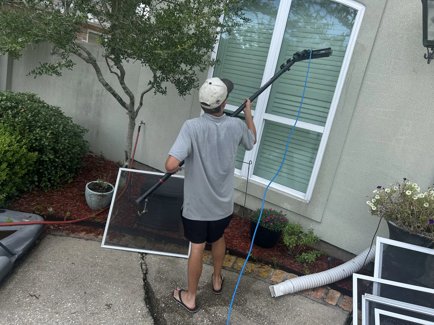 Boot Krewe technician cleaning a window with a water fed pole